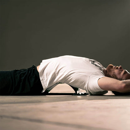 mand i hvid stretchfit tshirt liggende på rygstraekker backflex